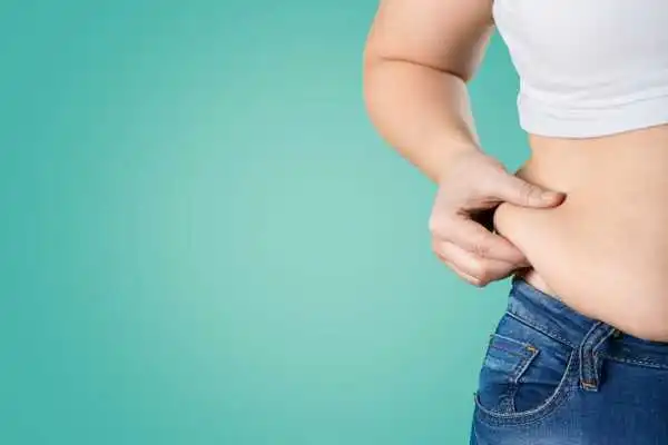 Image of woman pinching her love handles to show weight gain Camden